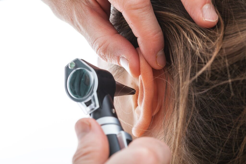 Person using ear thermometer to check ear temperature.