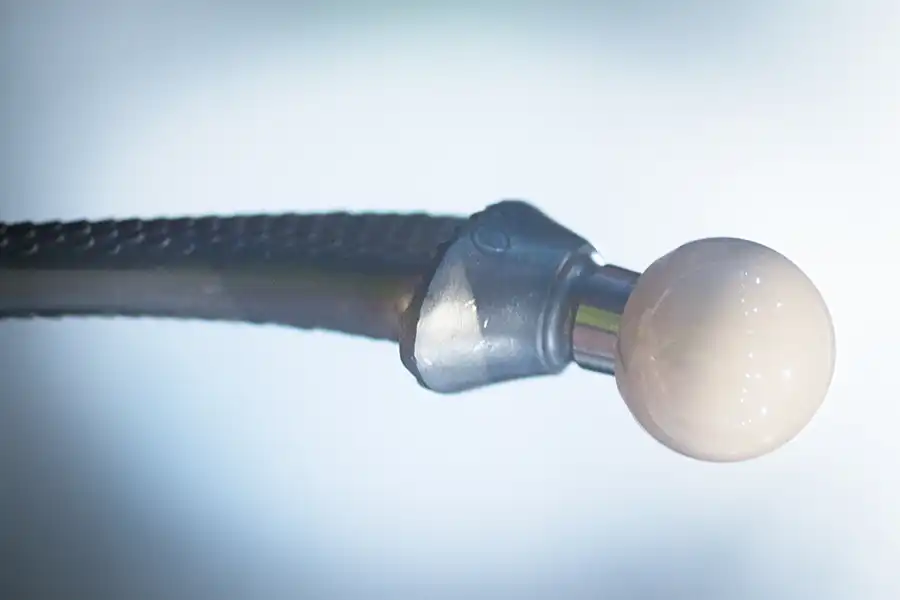 Image of white ball gripped by metal object, fda-role-hip-replacement-image.