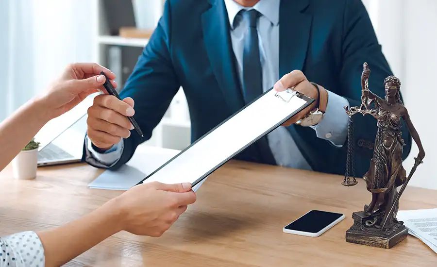 A man and woman in business attire sitting at a table, discussing work.