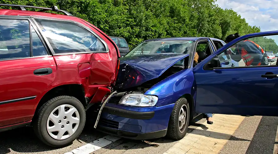Two cars involved in a collision, showing visible damage caused by a car accident.
