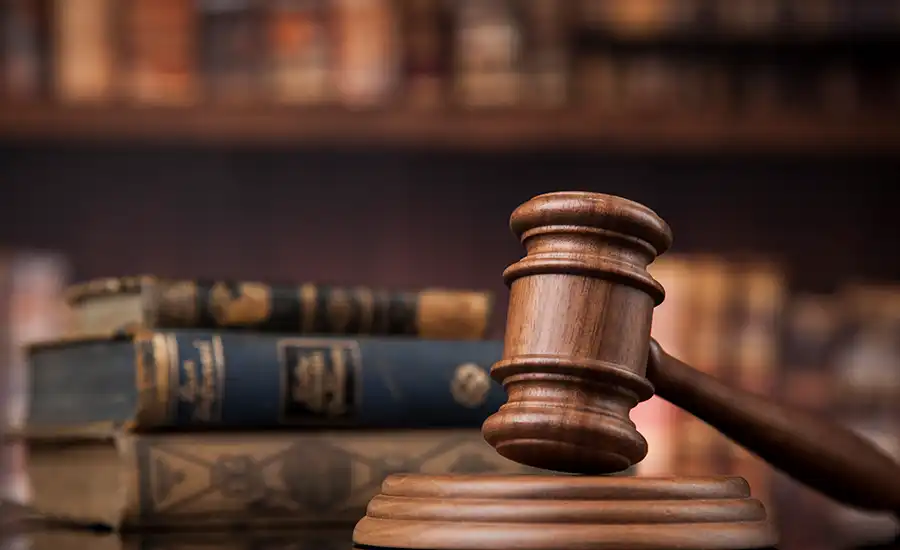 A gavel used by a judge, placed on a stack of books.