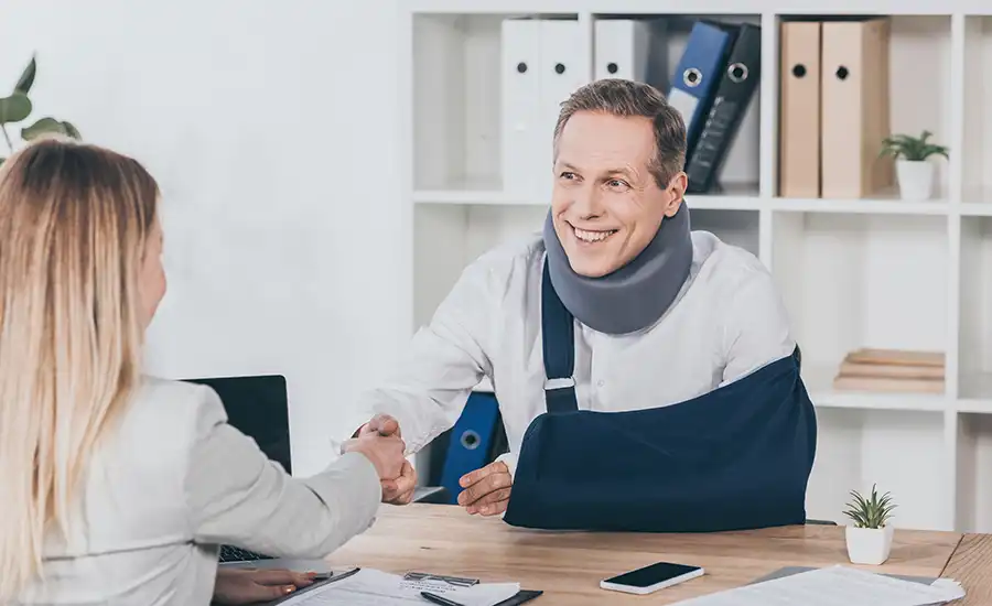 A man with a plaster cast on his arm shaking hands with a woman.