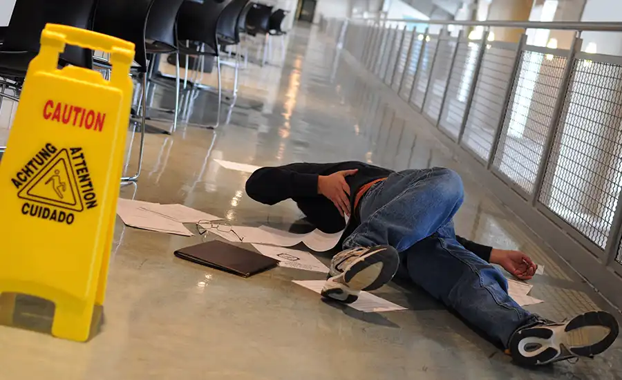 Caution sign next to a man laying on the floor.